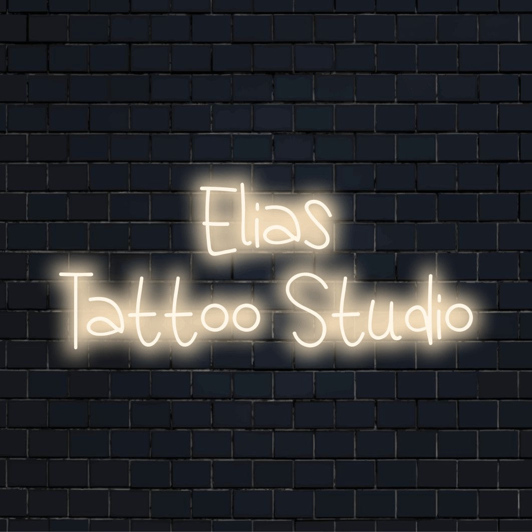 Elias Tattoo Studio Custom Name Neon Sign, bright neon glow on black brick background