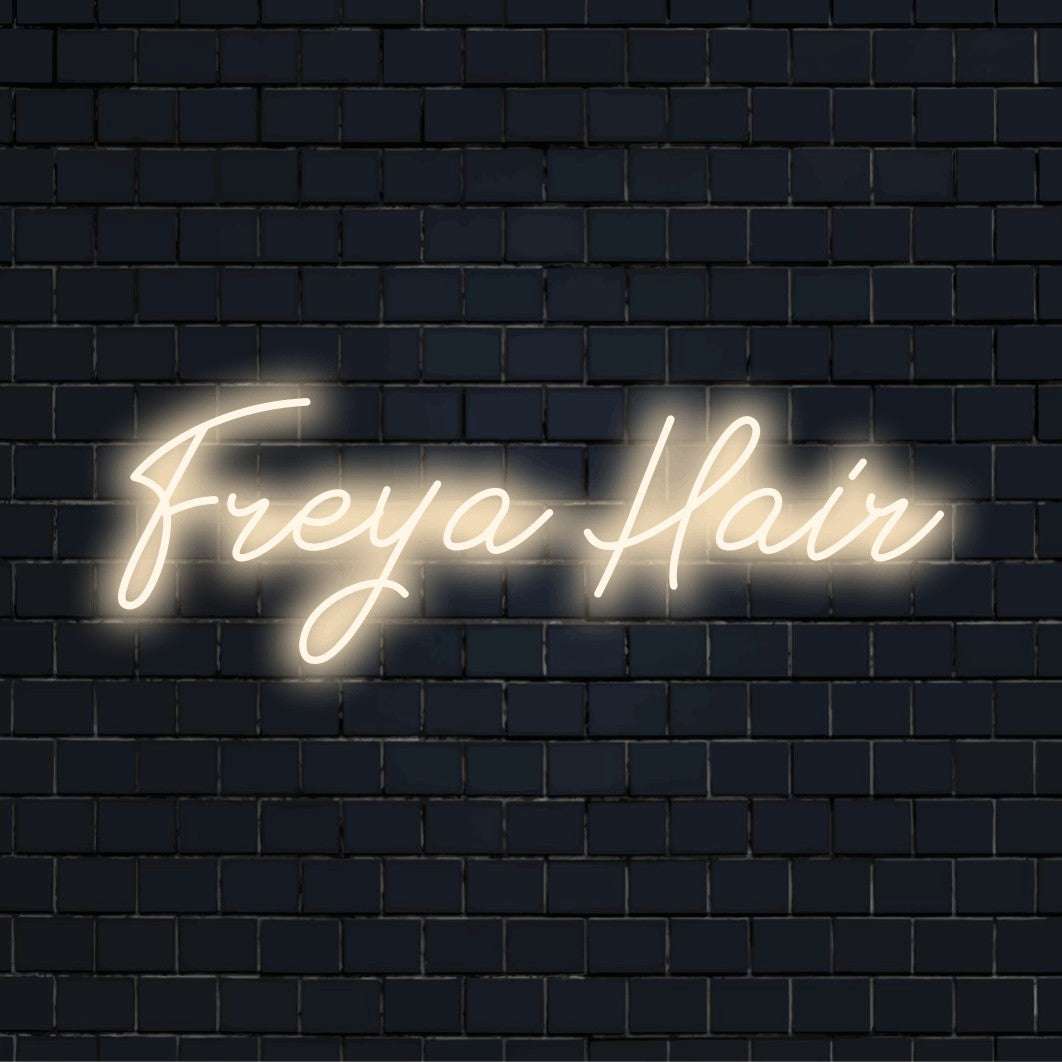Freya Hair Custom Name Neon Sign, bright neon lettering against brick backdrop