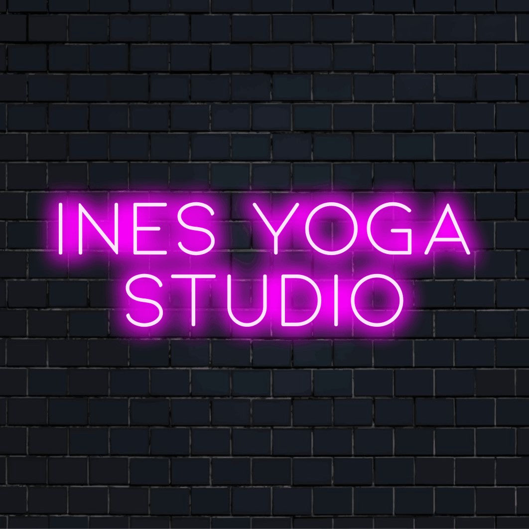 Ines Yoga Studio Personalized Neon Light with soft neon glow on dark brick background