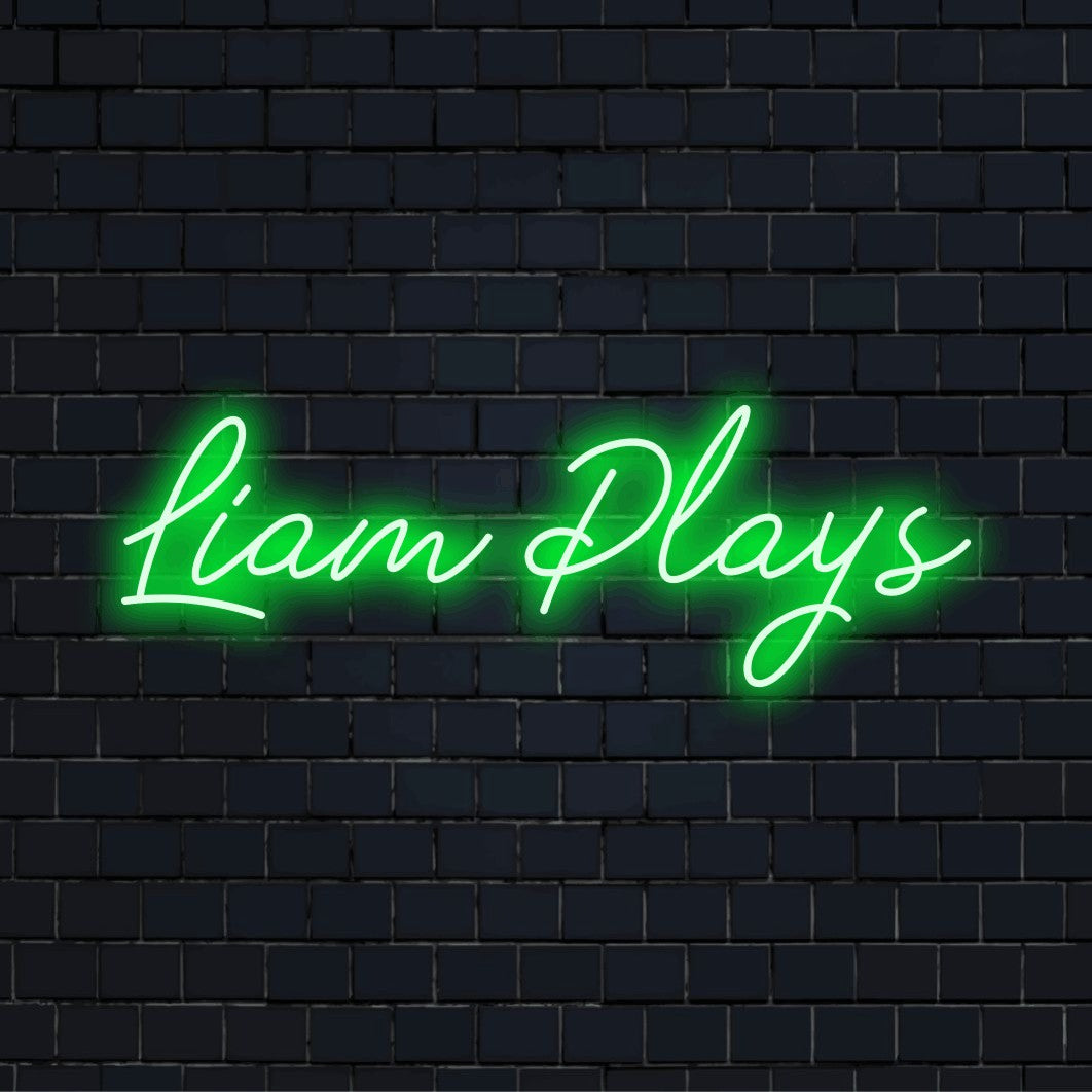Liam Plays Personalized LED Neon Sign, glowing lettering against black brick wall