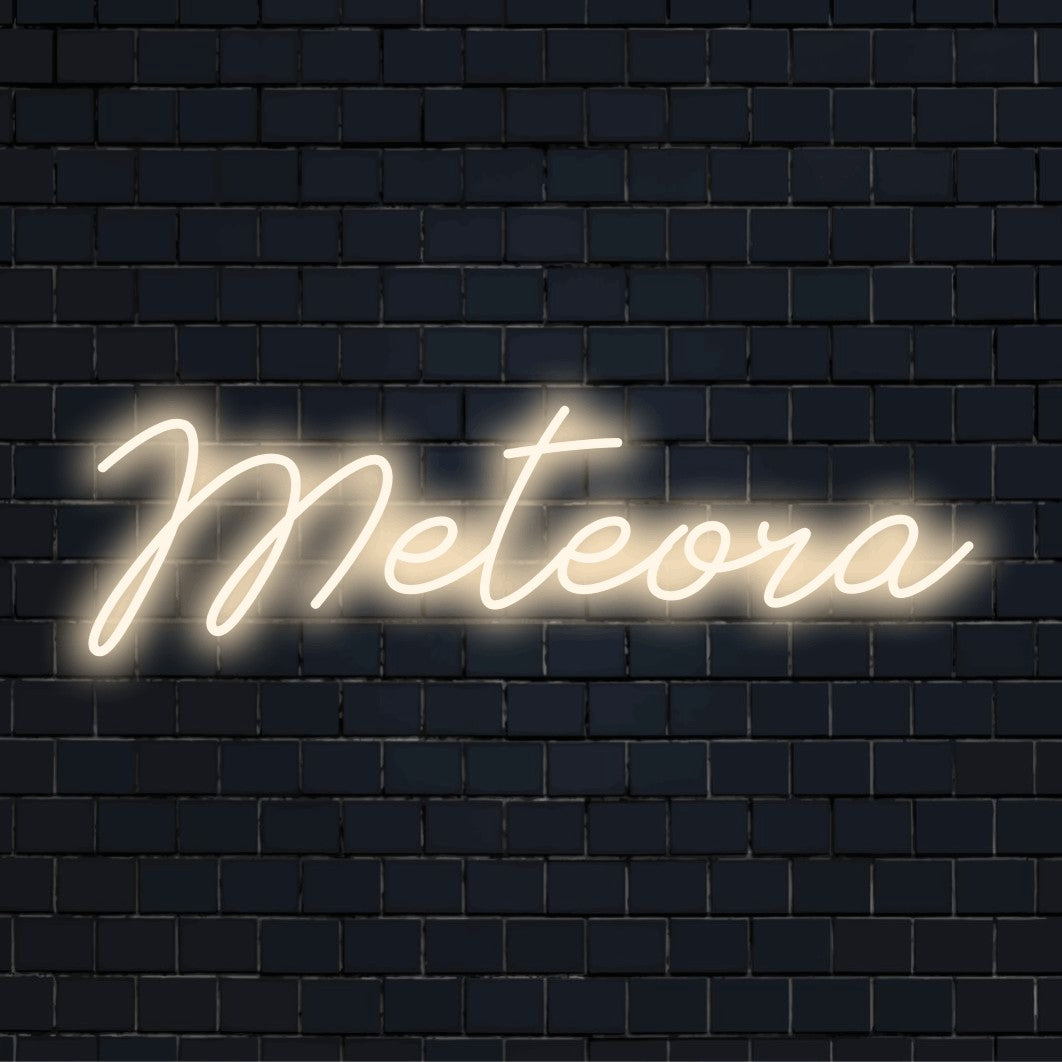 Meteora LED Neon Sign, neon text light on dark brick background