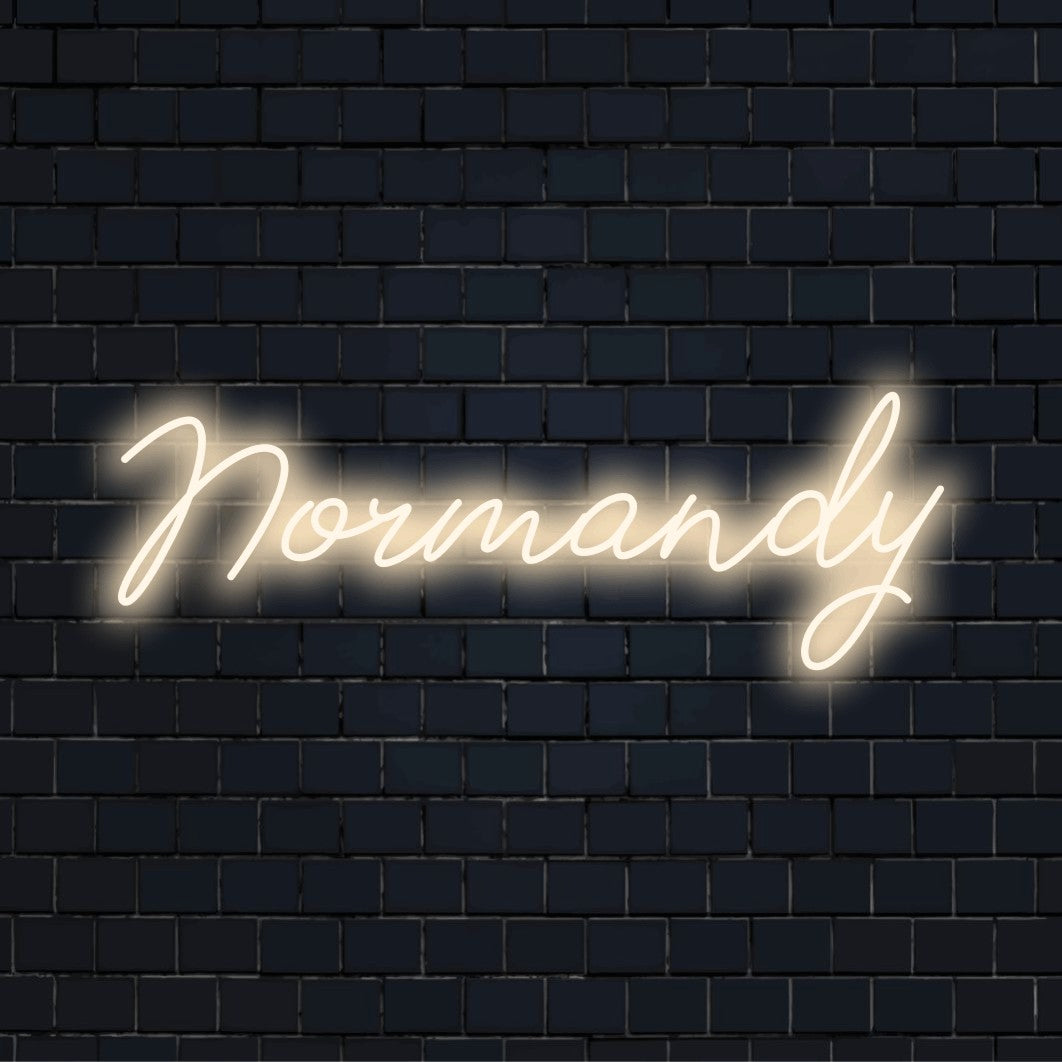 Normandy Neon Sign, bright neon lettering on black brick background