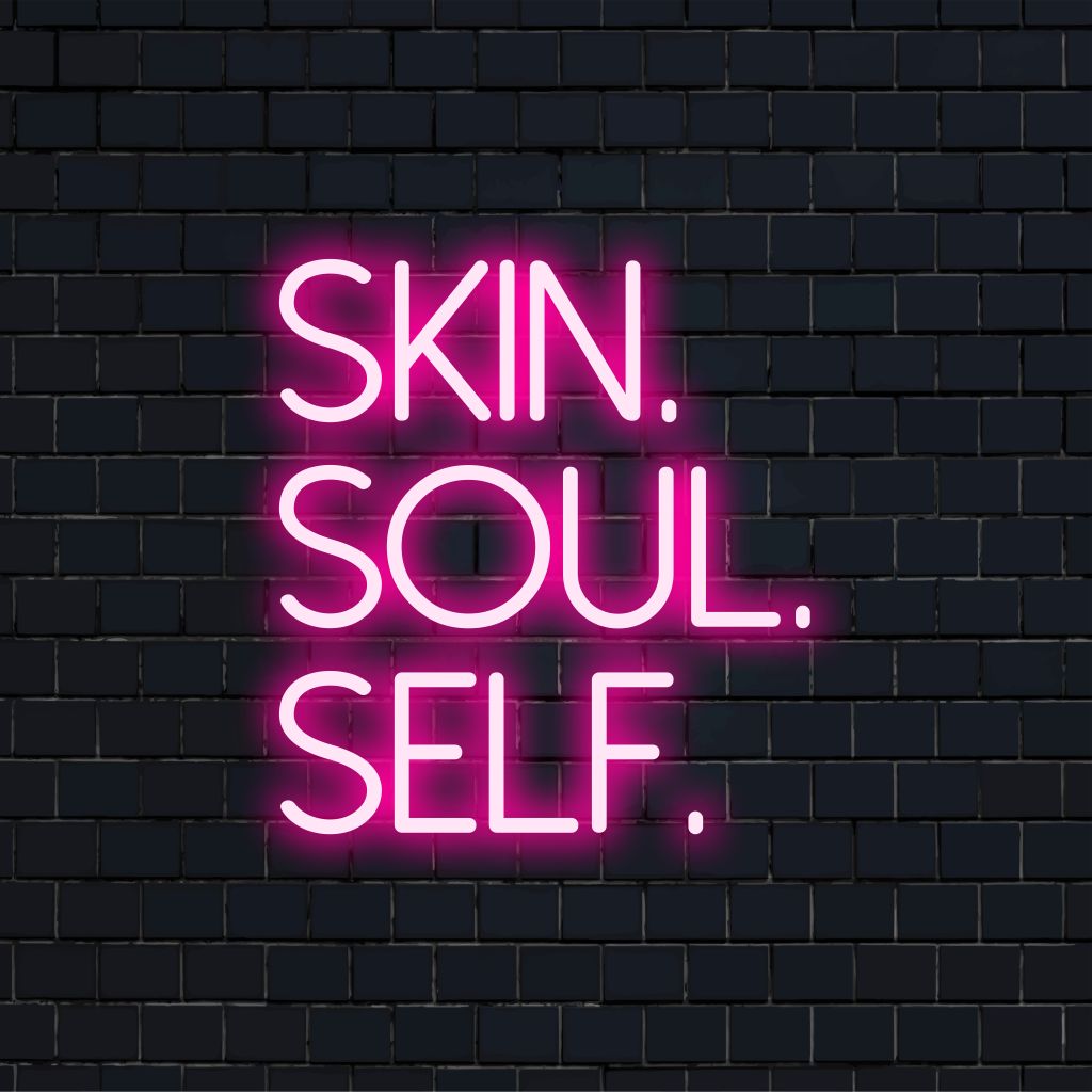 Skin Soul Self Neon Sign, bright LED glow on dark brick wall