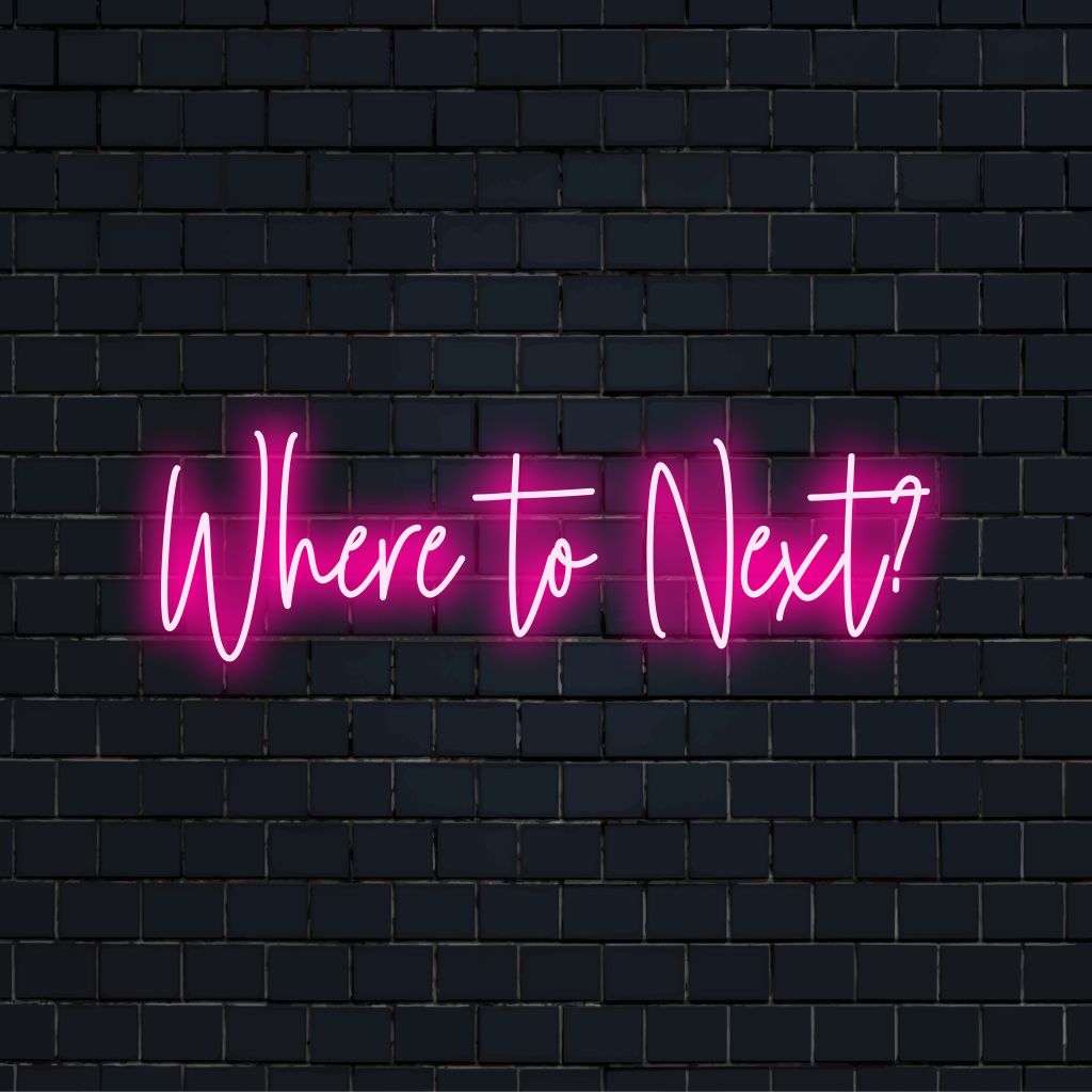 Where To Next Neon Sign, bright LED glow on dark brick wall