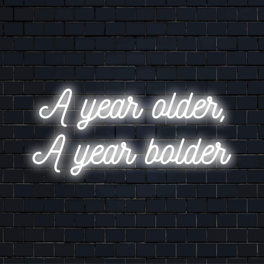Vibrant LED neon sign reading A Year Older, A Year Bolder as striking neon wall art and custom light decor.