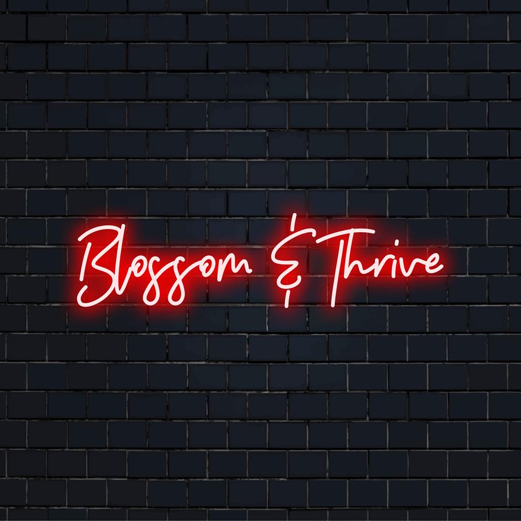 LED-Neonschild mit der Aufschrift „Blossom And Thrive“ in leuchtenden Farben, perfekt für inspirierende Neonkunst und -dekoration.
