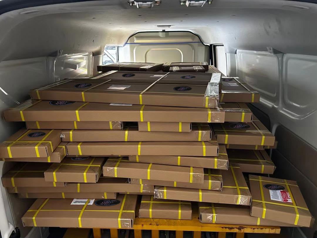 Mehrere zusammen verpackte Bestellungen von The Art Neon in einem Lieferfahrzeug