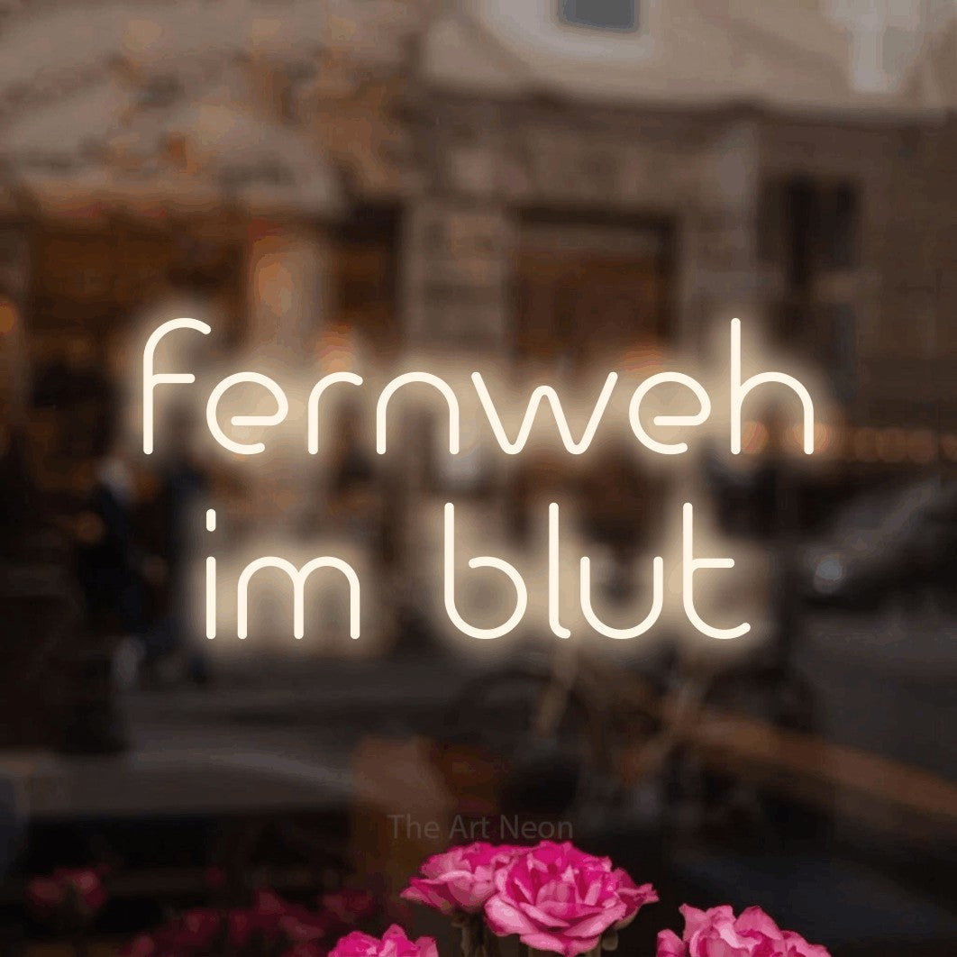 LED neon sign reading “fernweh im blut”, arranged in 2 lines.