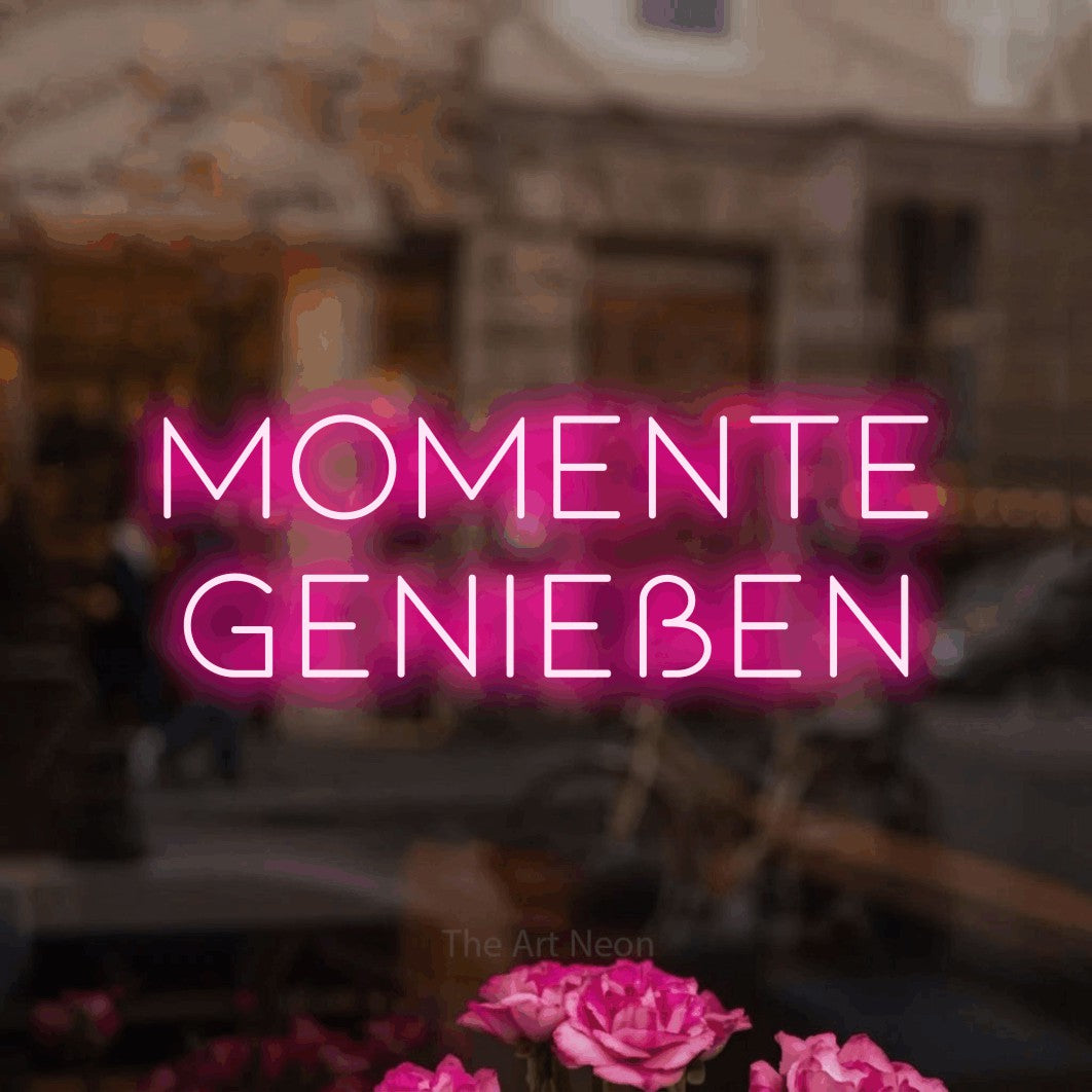 LED neon sign reading “momente genießen”, arranged in 2 lines.