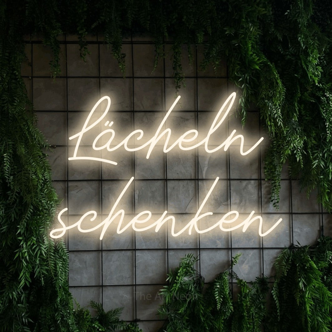 LED neon sign reading “Lächeln schenken”, arranged in 2 lines.