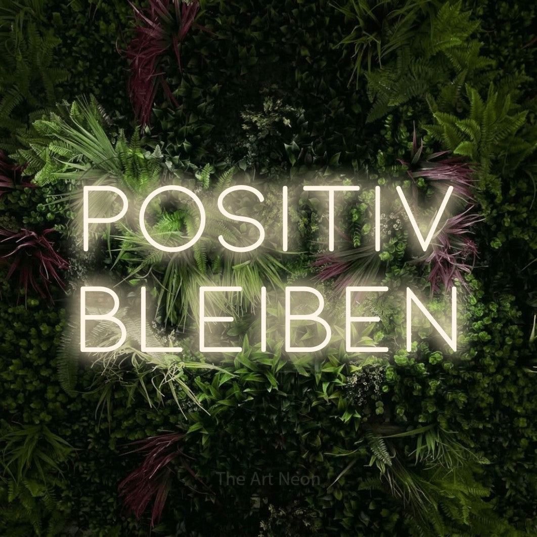 LED neon sign reading “Positiv bleiben”, arranged in 2 lines.