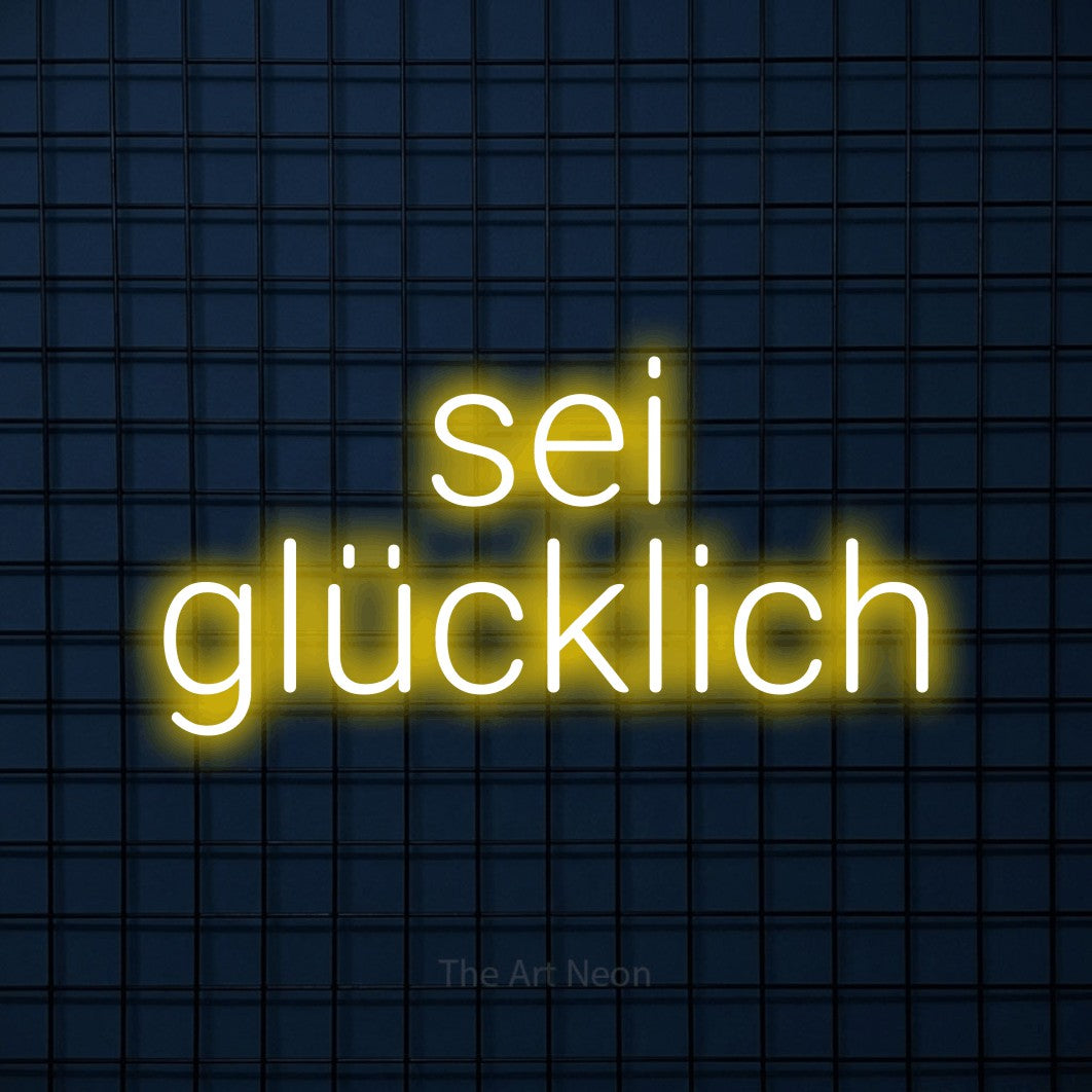 LED neon sign reading “sei glücklich”, arranged in 2 lines.