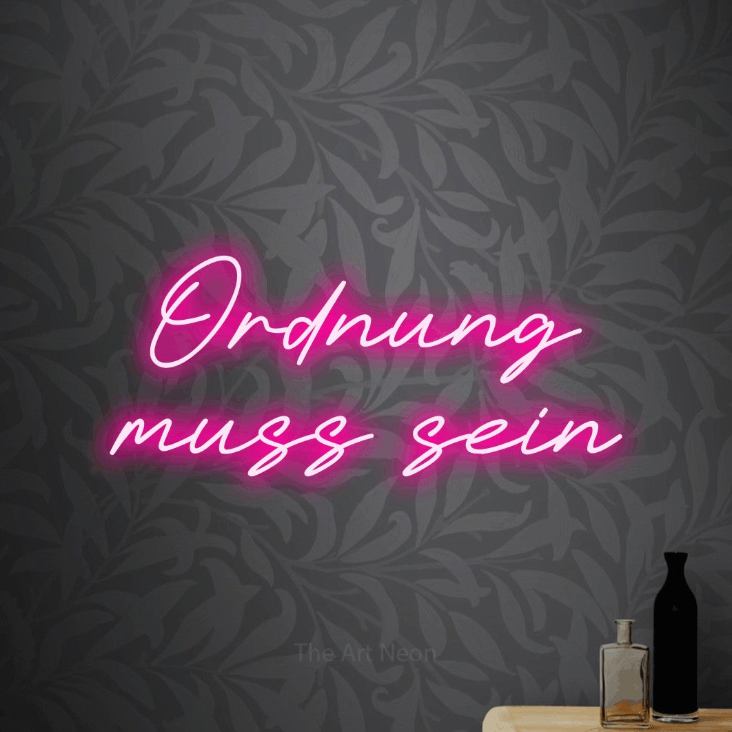 LED neon sign reading “Ordnung muss sein”, arranged in 2 lines.