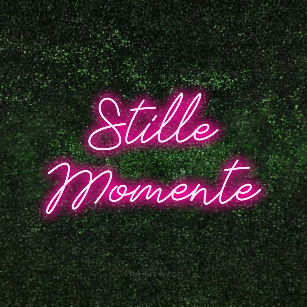 LED neon sign reading “Stille Momente”, arranged in 2 lines.