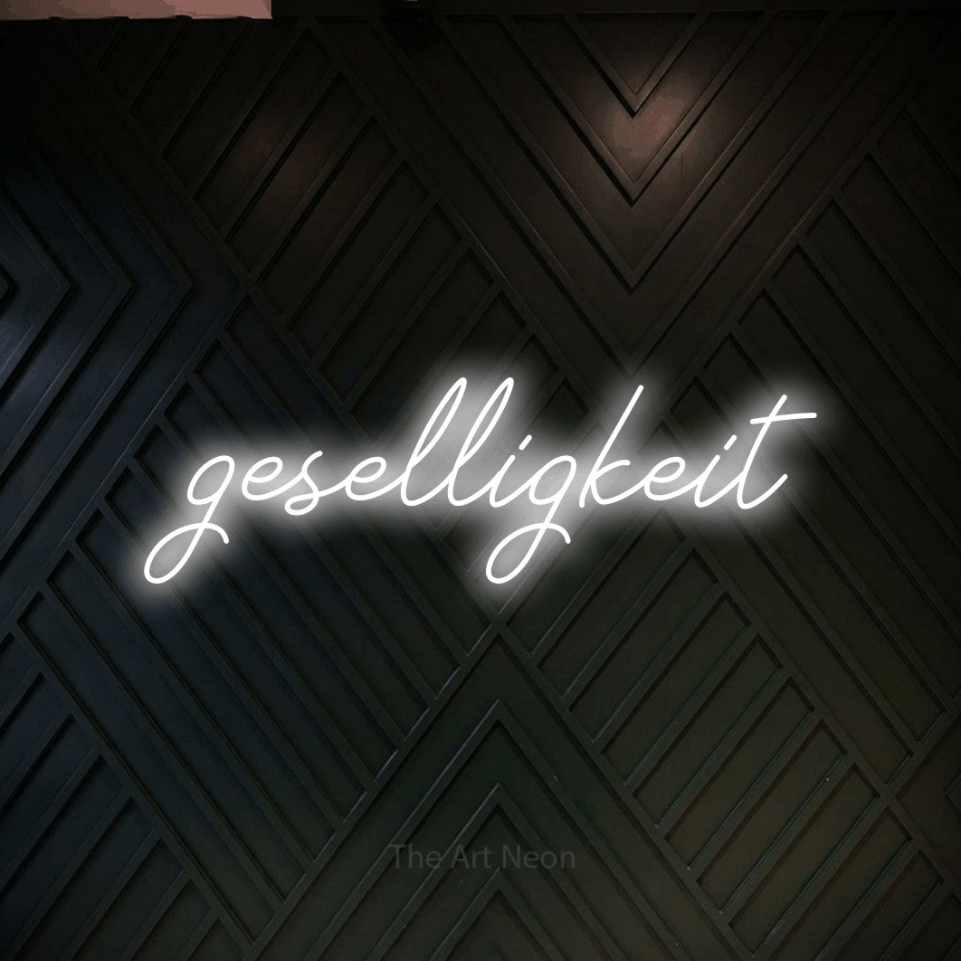 LED neon sign reading “geselligkeit”, arranged in a single line.
