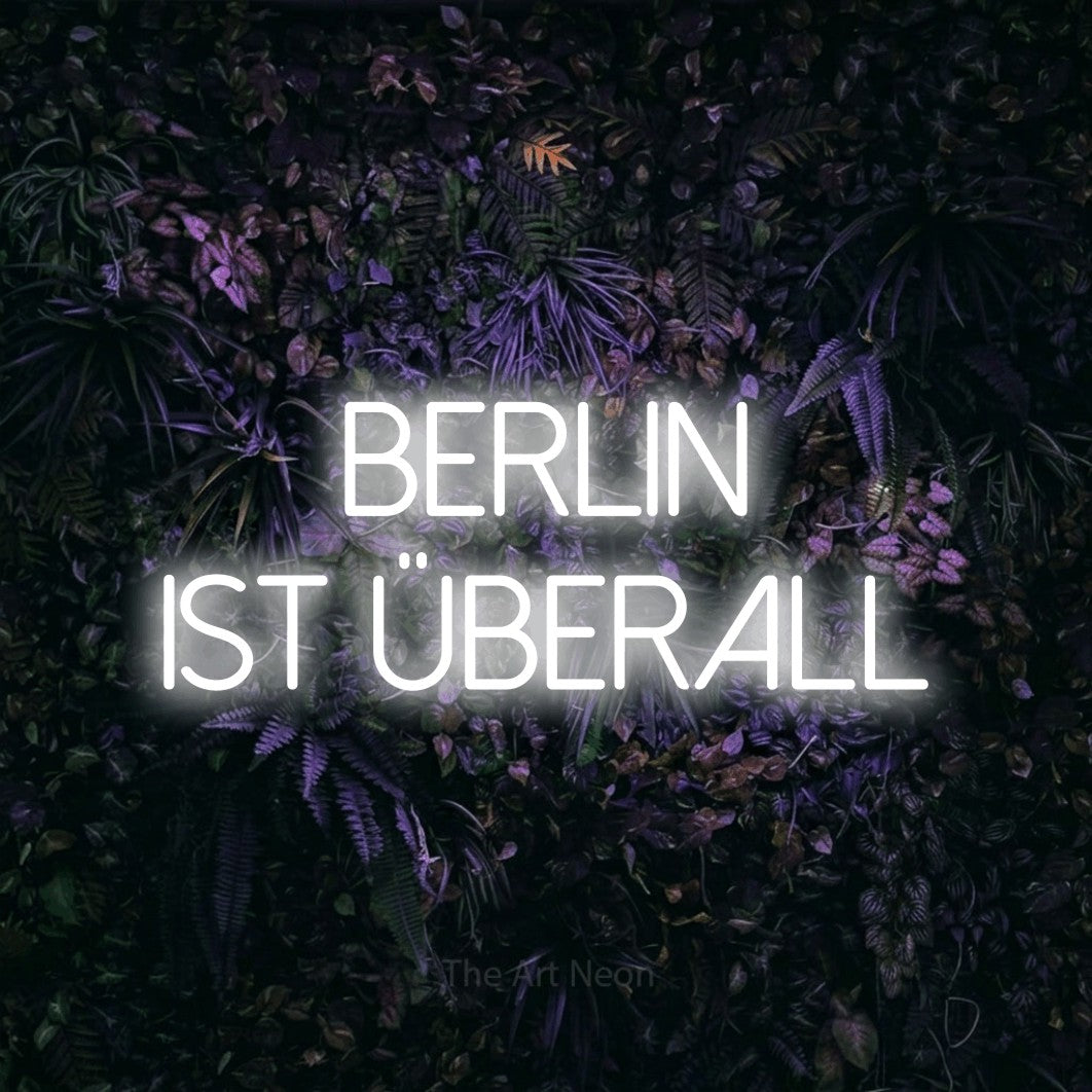 LED neon sign reading “berlin ist überall”, arranged in 2 lines.