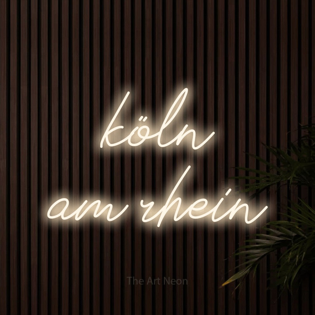 LED neon sign reading “köln am rhein”, arranged in 2 lines.