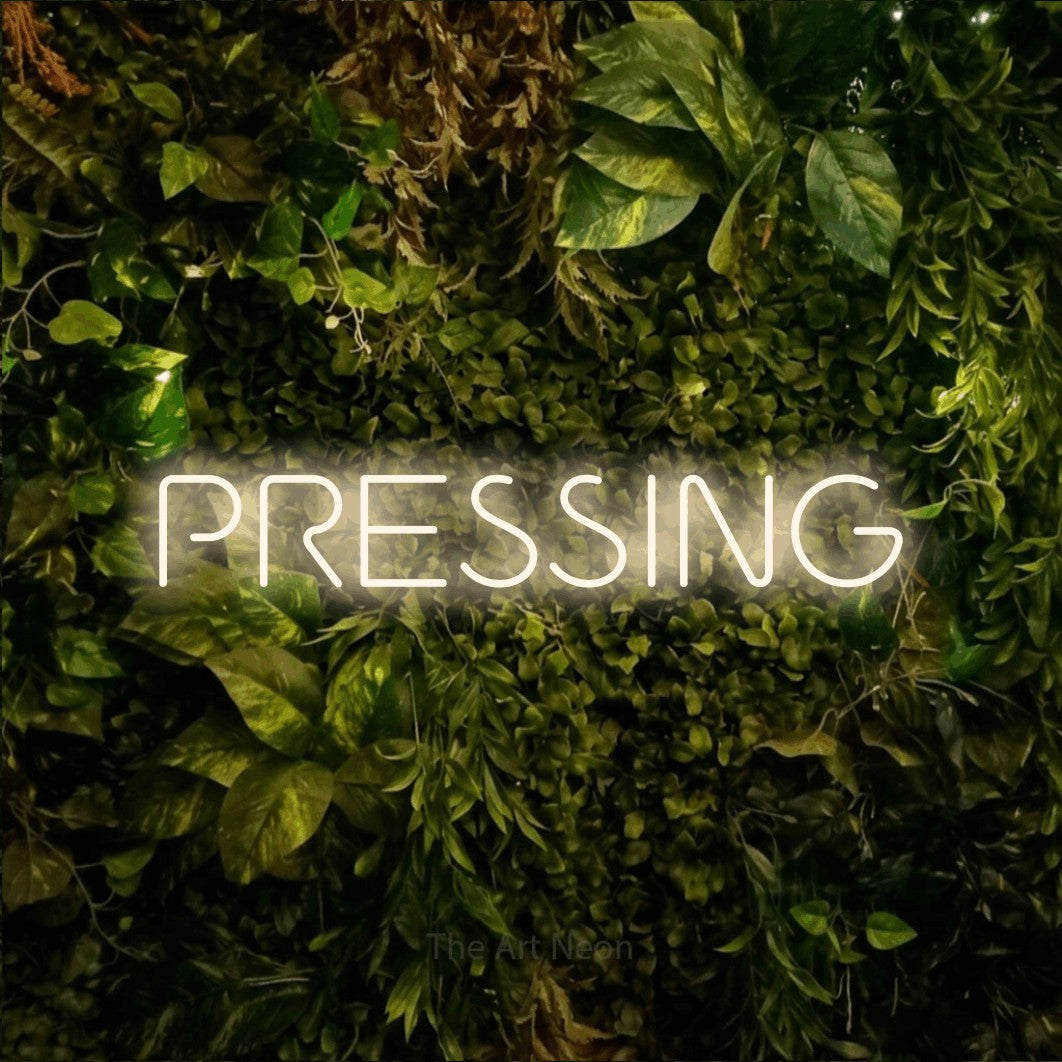 LED neon sign reading “PRESSING”, arranged in a single line.