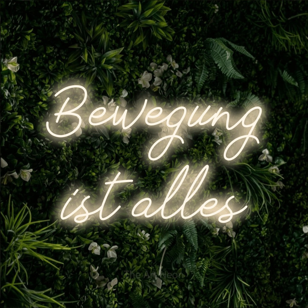 LED neon sign reading “Bewegung ist alles”, arranged in 2 lines.