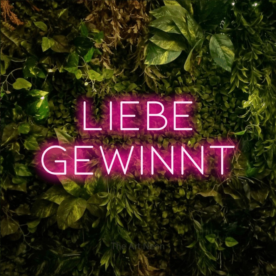 LED neon sign reading “Liebe gewinnt”, arranged in 2 lines.