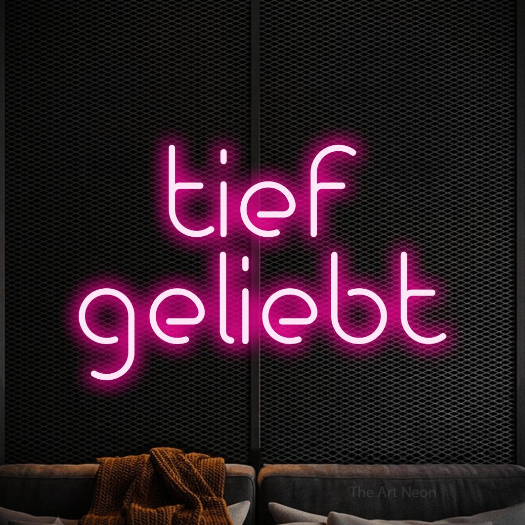 LED neon sign reading “tief geliebt”, arranged in 2 lines.