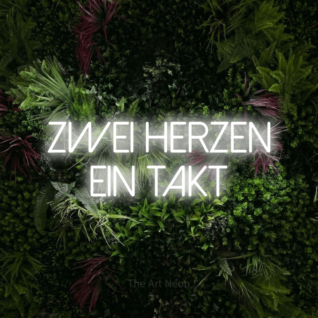 LED neon sign reading “Zwei Herzen ein Takt”, arranged in 2 lines.