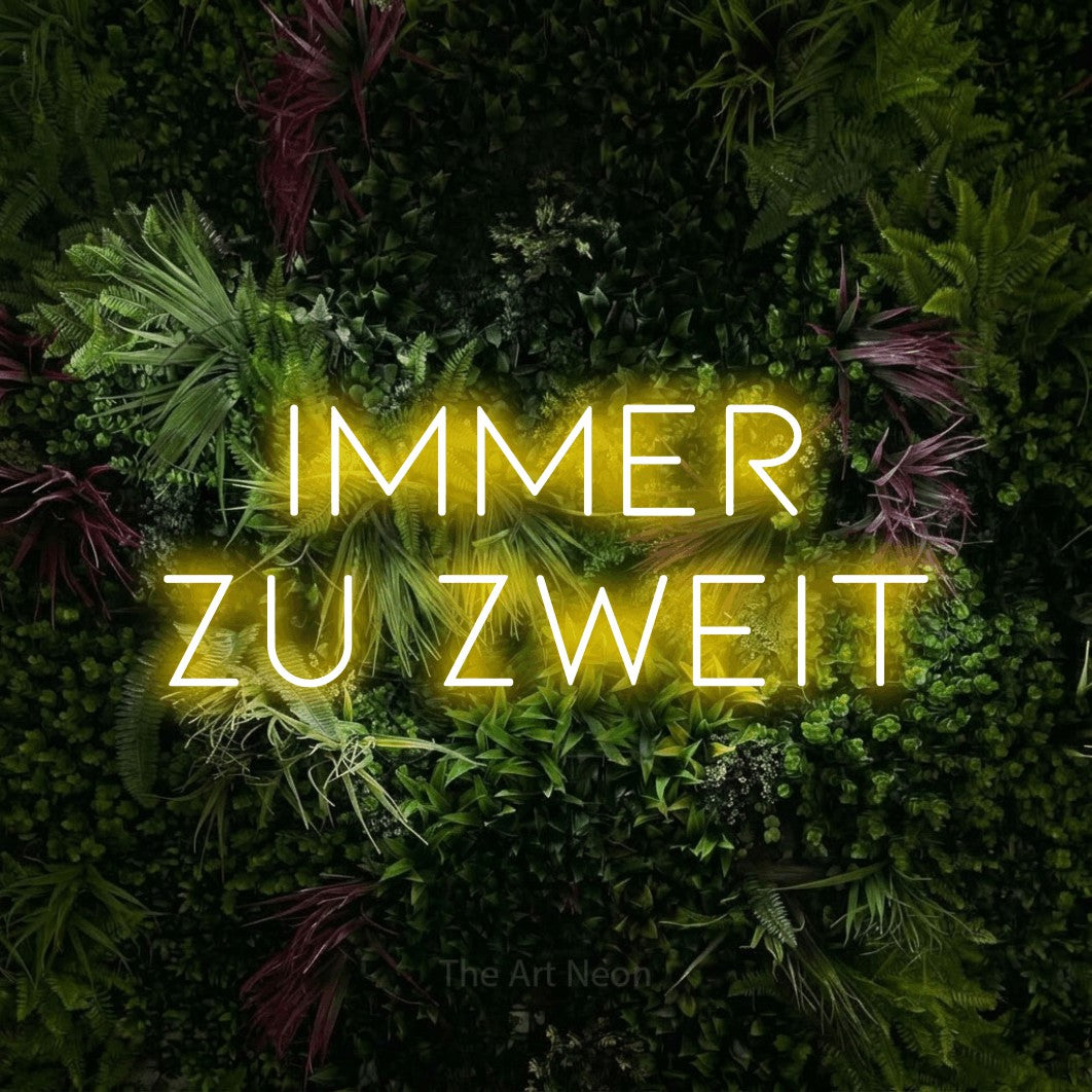 LED neon sign reading “immer zu zweit”, arranged in 2 lines.