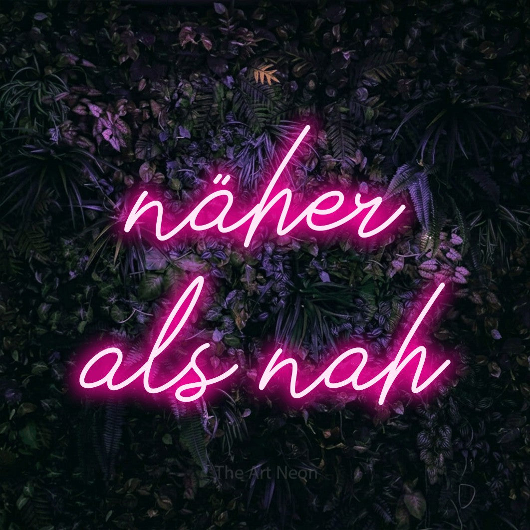 LED neon sign reading “näher als nah”, arranged in 2 lines.