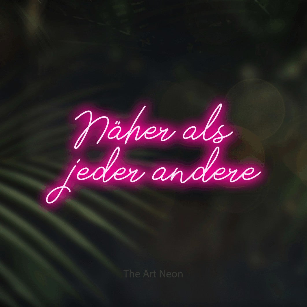 LED neon sign reading “Näher als jeder andere”, arranged in 2 lines.