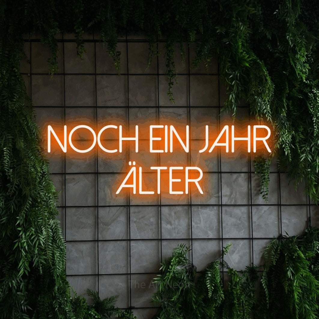 LED neon sign reading “noch ein jahr ÄLTER”, arranged in 2 lines.