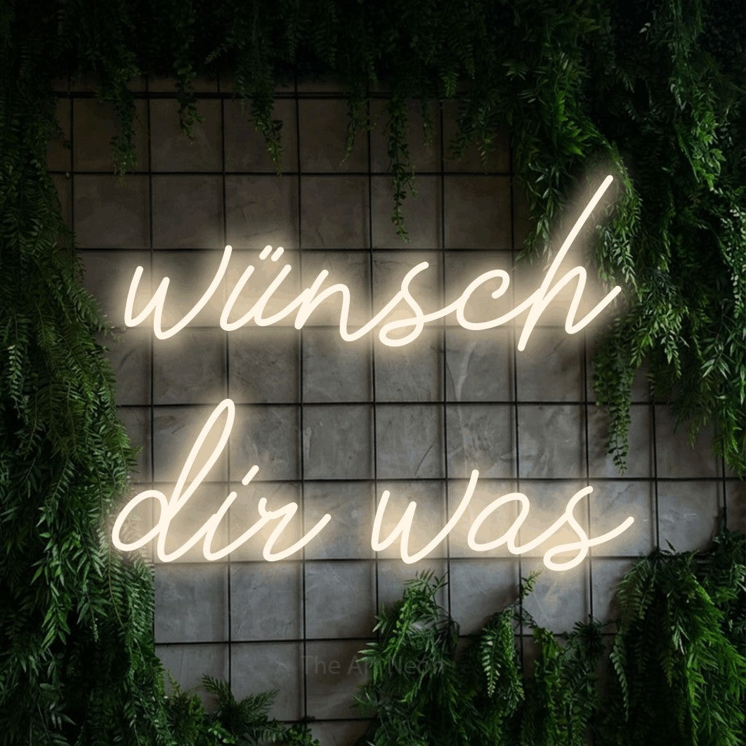 LED neon sign reading “wünsch dir was”, arranged in 2 lines.