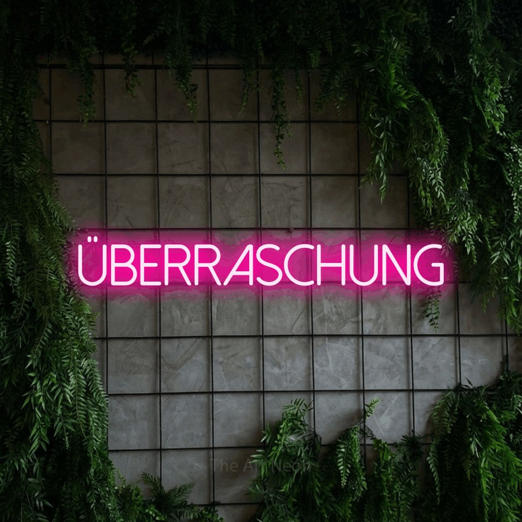 LED neon sign reading “Überraschung”, arranged in a single line.