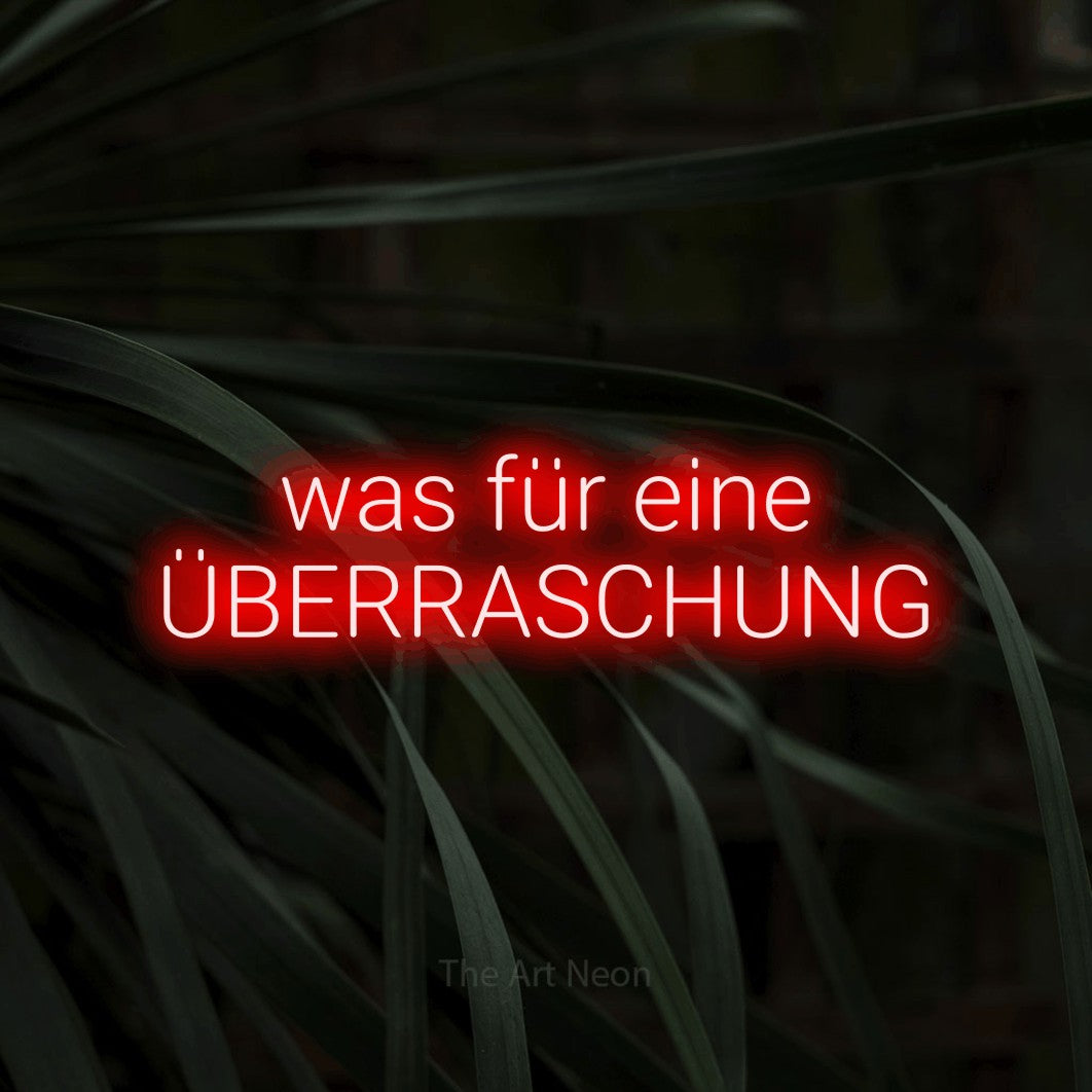 LED neon sign reading “was für eine ÜBERRASCHUNG”, arranged in 2 lines.
