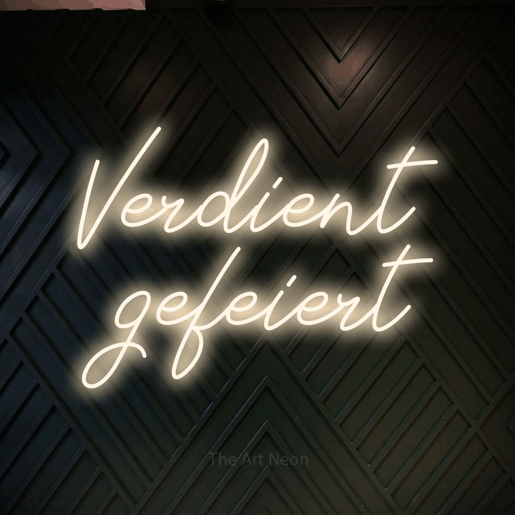 LED neon sign reading “Verdient gefeiert”, arranged in 2 lines.
