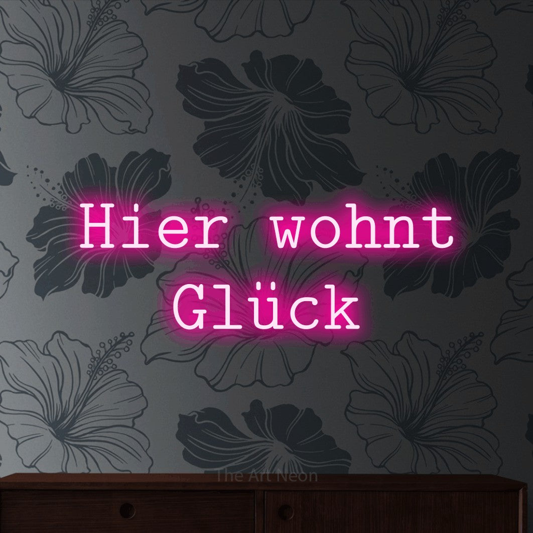 LED neon sign reading “Hier wohnt Glück”, arranged in 2 lines.