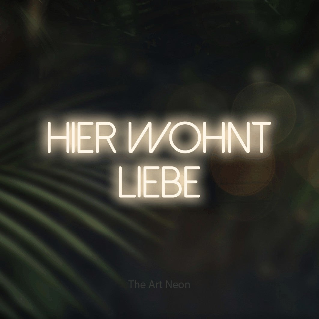 LED neon sign reading “hier wohnt liebe”, arranged in 2 lines.