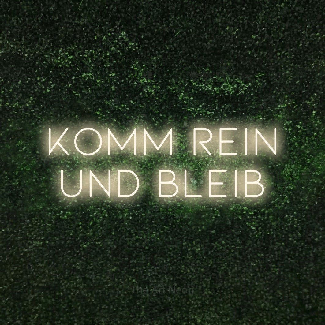 LED neon sign reading “Komm rein und bleib”, arranged in 2 lines.