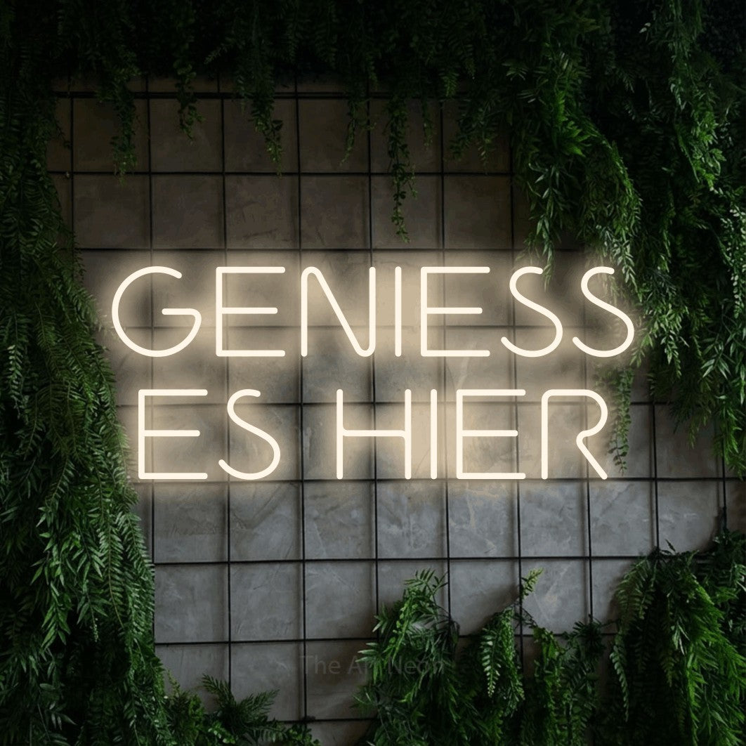 LED neon sign reading “GENIESS ES HIER”, arranged in 2 lines.