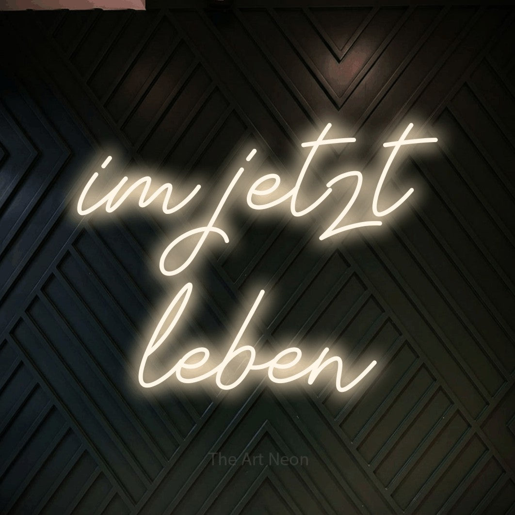 LED neon sign reading “im jetzt leben”, arranged in 2 lines.