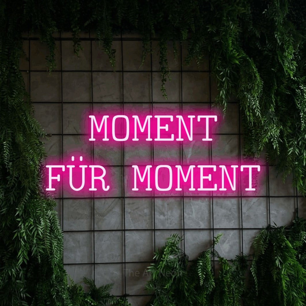 LED neon sign reading “MOMENT FÜR MOMENT”, arranged in 2 lines.