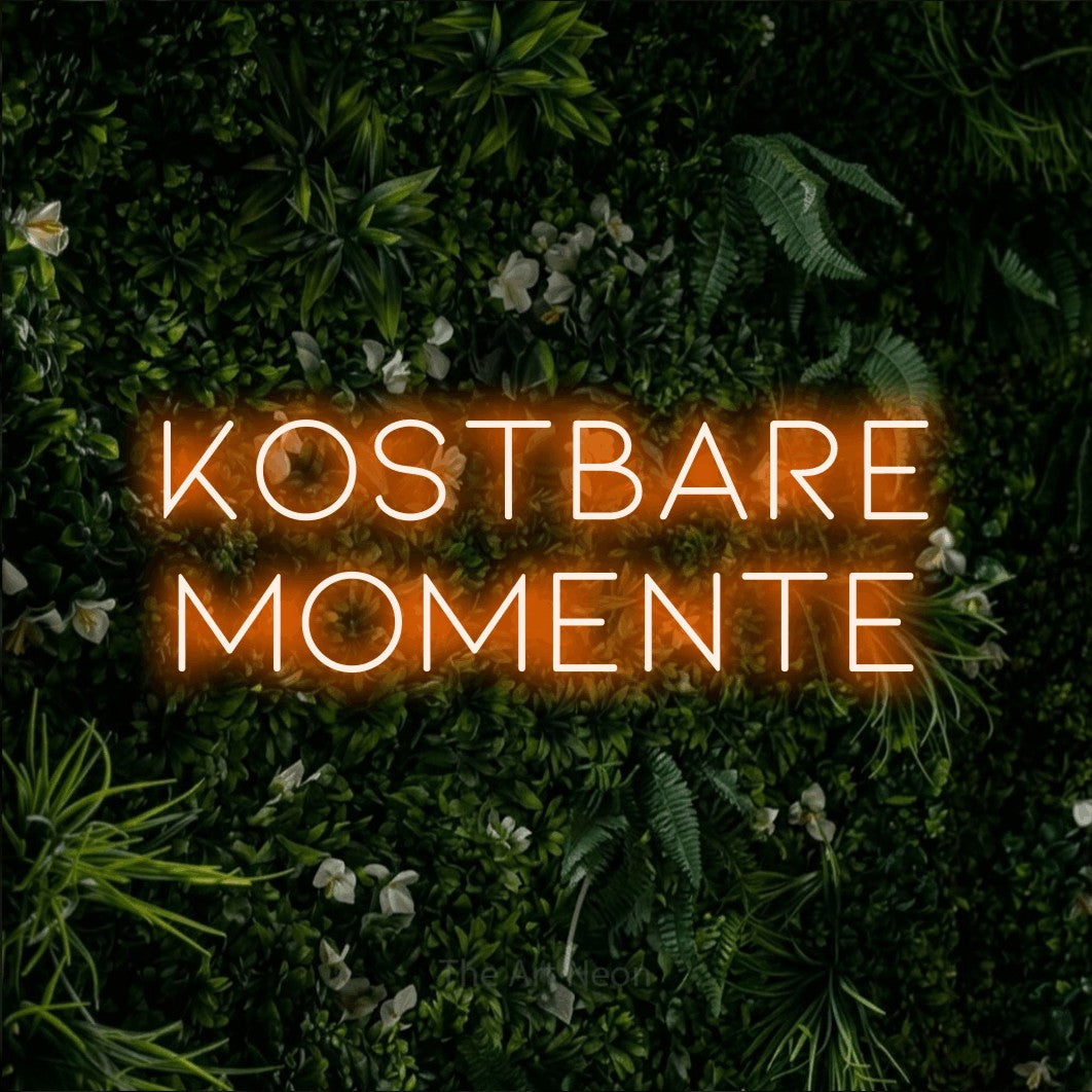 LED neon sign reading “kostbare momente”, arranged in 2 lines.