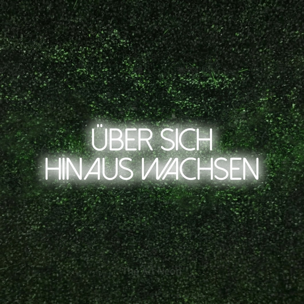 LED neon sign reading “Über sich hinaus wachsen”, arranged in 2 lines.