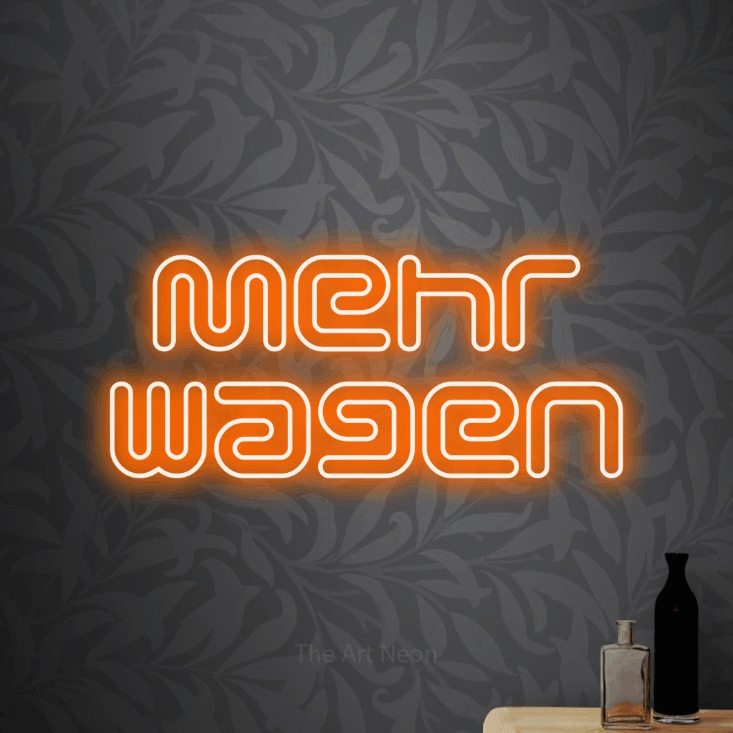 LED neon sign reading “Mehr wagen”, arranged in 2 lines.