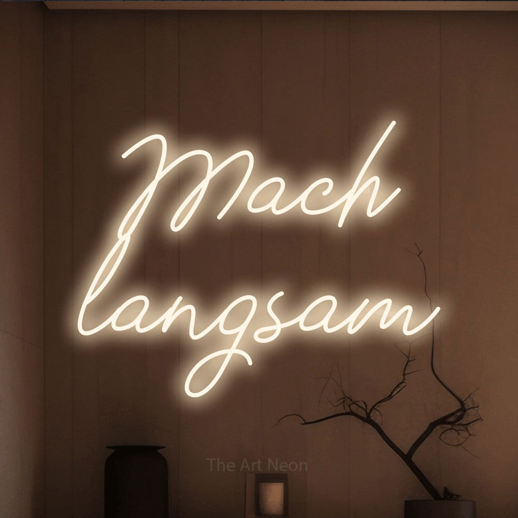LED neon sign reading “Mach langsam”, arranged in 2 lines.