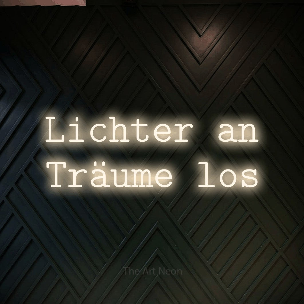 LED neon sign reading “Lichter an Träume los”, arranged in 2 lines.