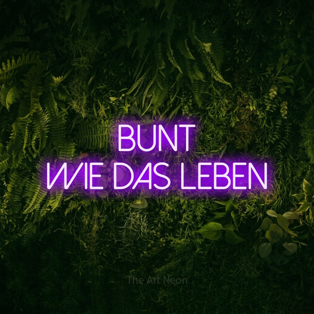 LED neon sign reading “bunt wie das leben”, arranged in 2 lines.
