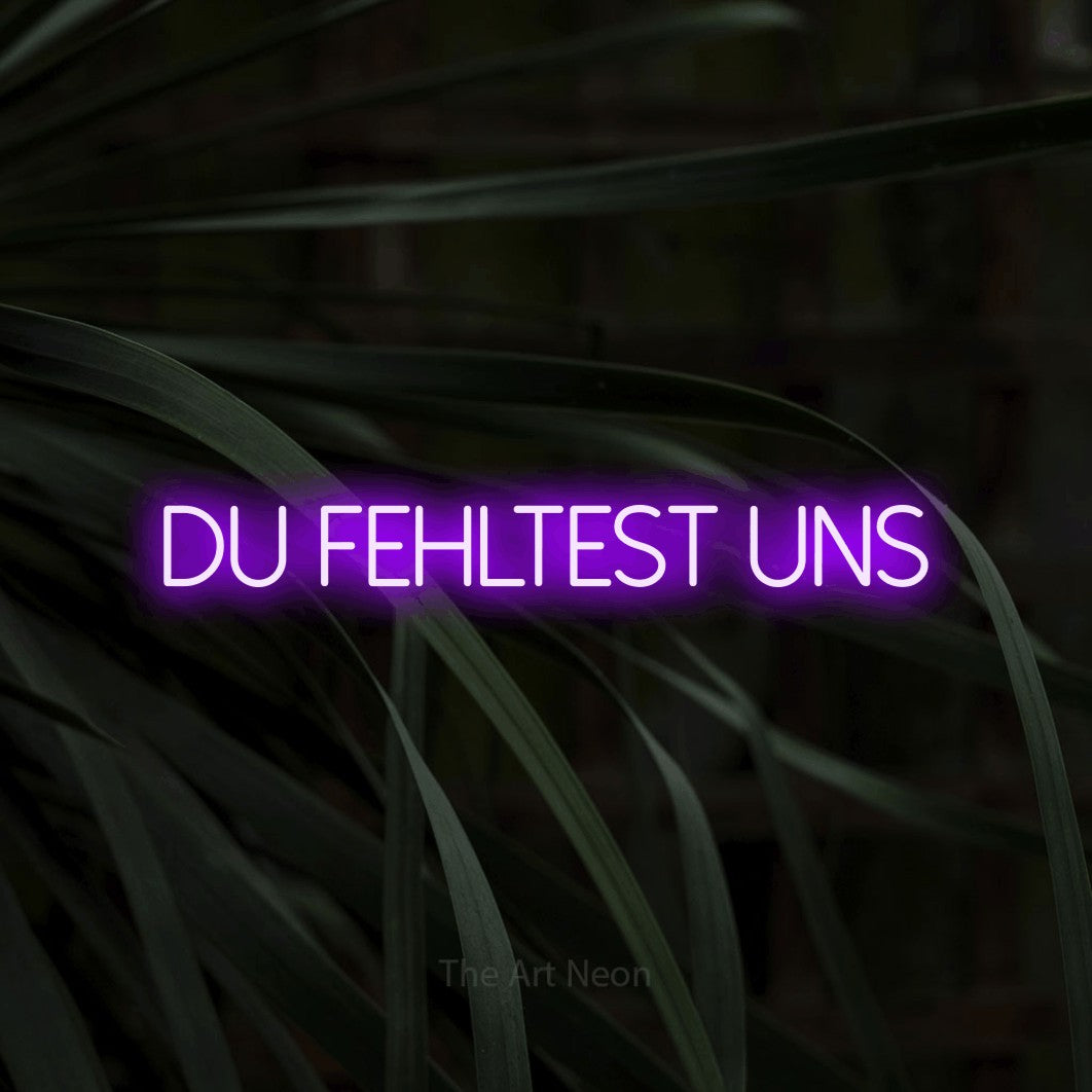 LED neon sign reading “du FEHLTEST uns”, arranged in a single line.