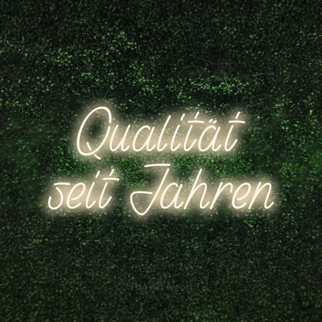 LED neon sign reading “Qualität seit Jahren”, arranged in 2 lines.