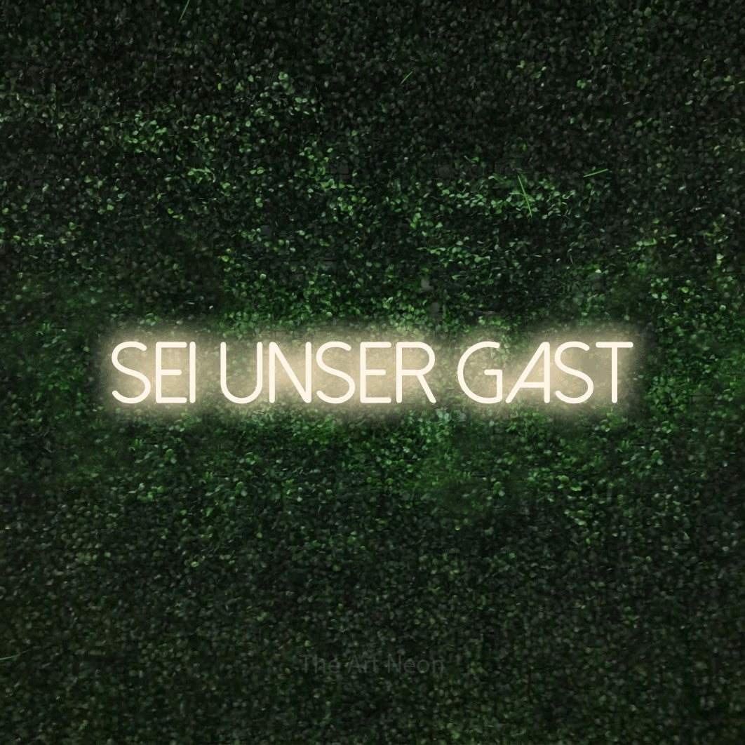 LED neon sign reading “sei unser gast”, arranged in a single line.