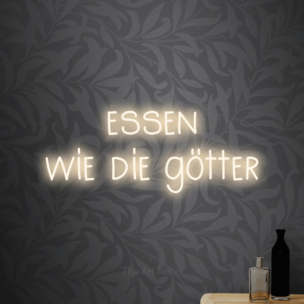 LED neon sign reading “essen wie die götter”, arranged in 2 lines.
